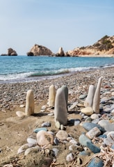 a group of rocks sitting on top of a sandy beach