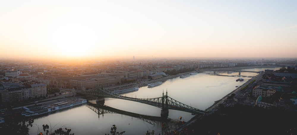 a bridge over a body of water with a city in the background