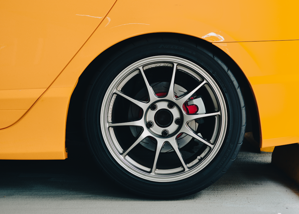 a close up of a wheel on a yellow sports car