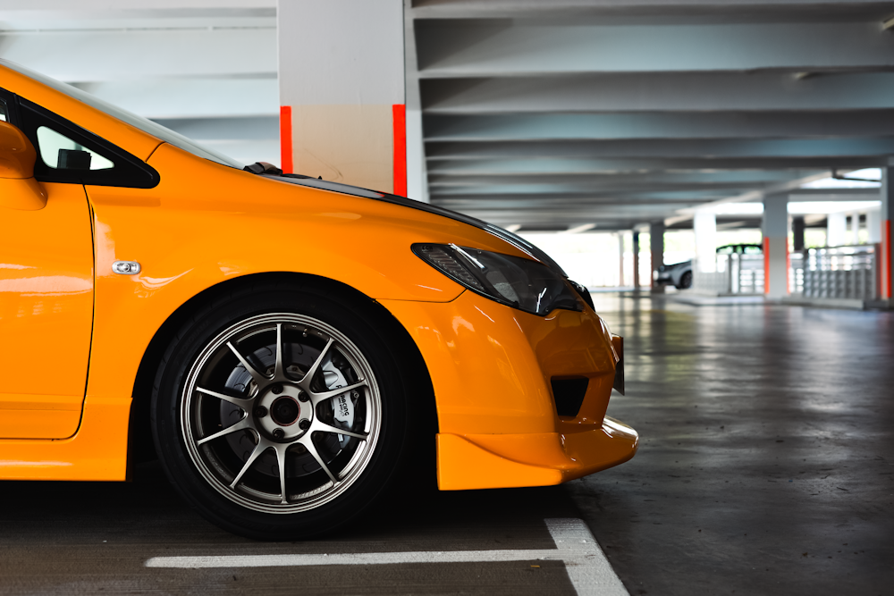 a yellow car parked in a parking garage