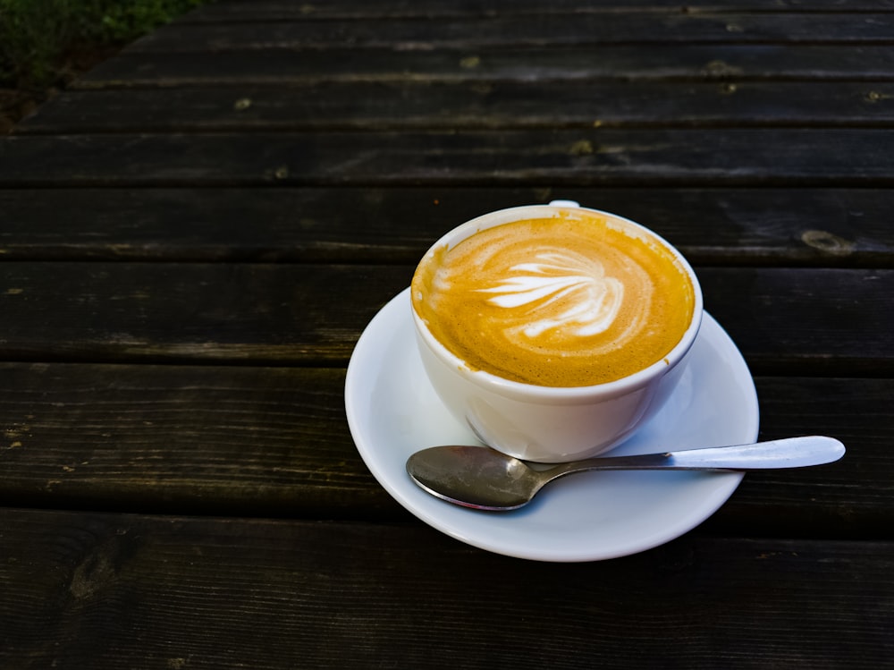 a cup of coffee on a saucer with a spoon