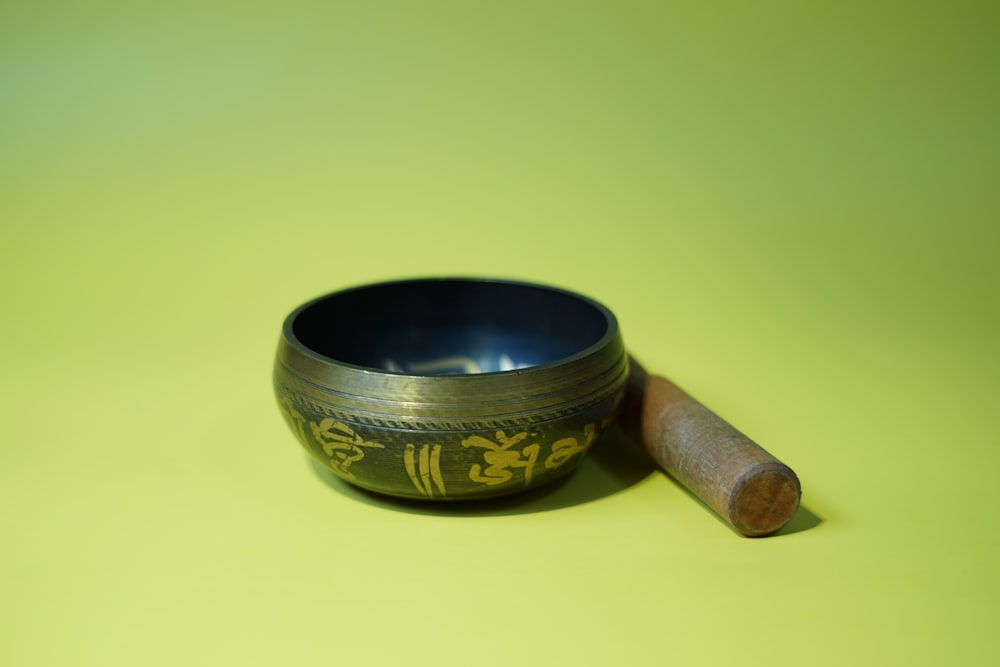 un cuenco tibetano de metal con un palo de madera