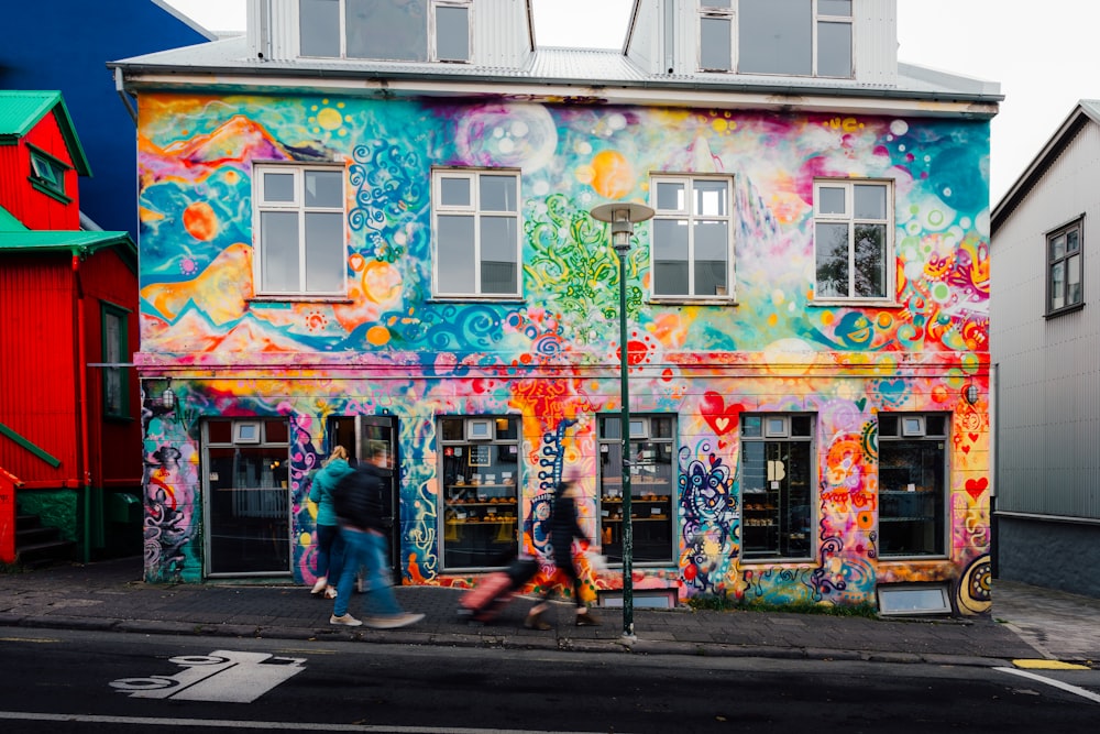 a multicolored building with people walking by it