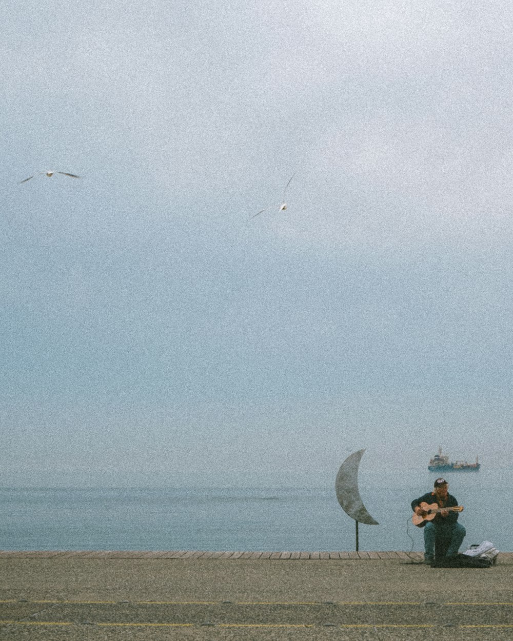 a man sitting on a bench next to the ocean