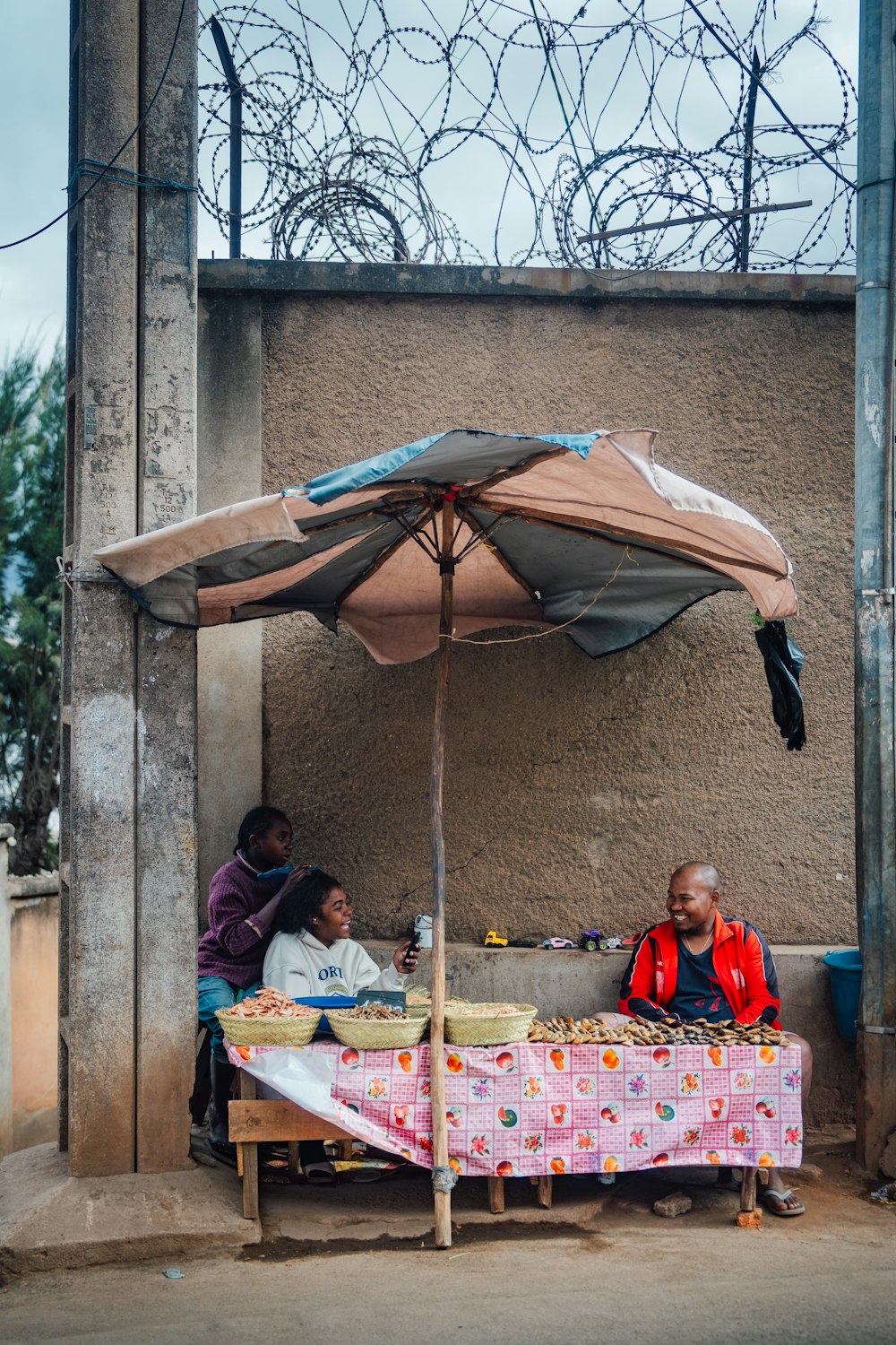 a couple of people sitting at a table under an umbrella