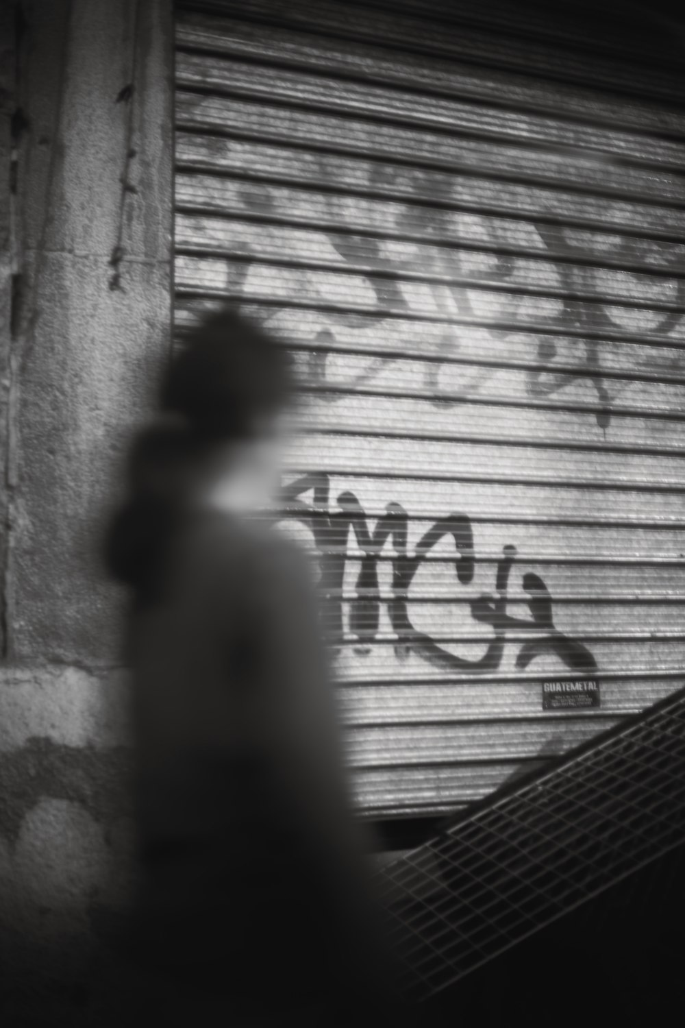 a person standing in front of a building with graffiti on it