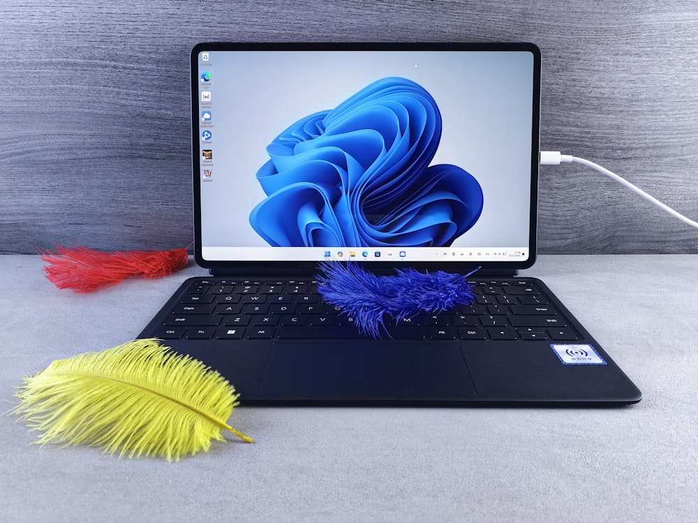 a macbook pro with a feather on the keyboard