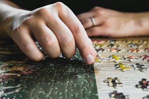 a close up of a person's hand on a puzzle