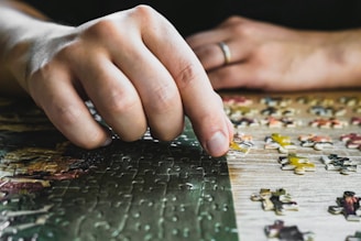 a close up of a person's hand on a puzzle