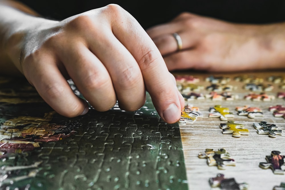 a close up of a person's hand on a puzzle