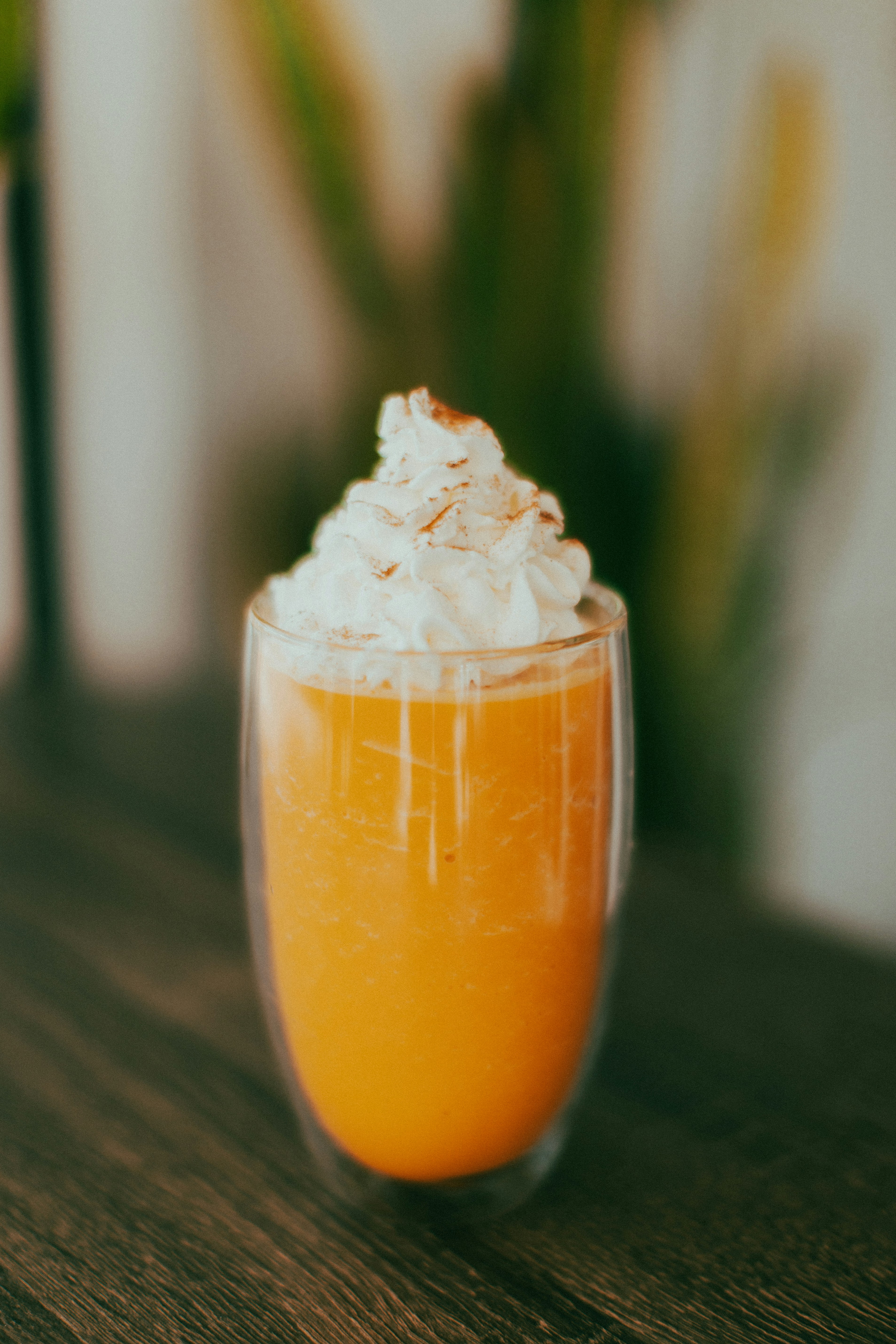 a glass of orange juice on a wooden table