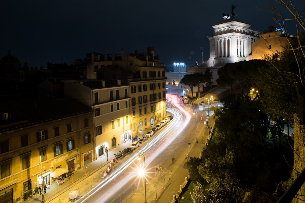 a city street at night with a clock tower in the background