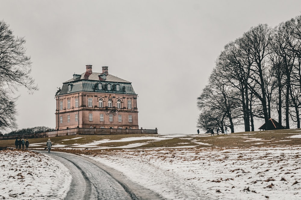 un grande edificio seduto in cima a un campo innevato