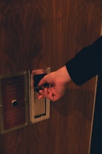 a person opening a door with their hand
