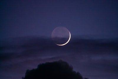 a crescent moon is seen in the night sky
