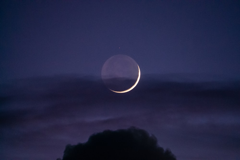 Un croissant de lune est vu dans le ciel nocturne