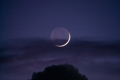 a crescent moon is seen in the night sky