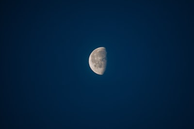 a half moon in a dark blue sky