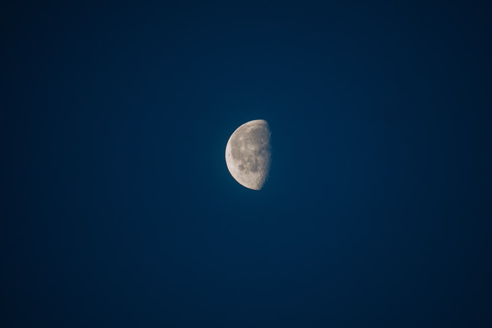 a half moon in a dark blue sky