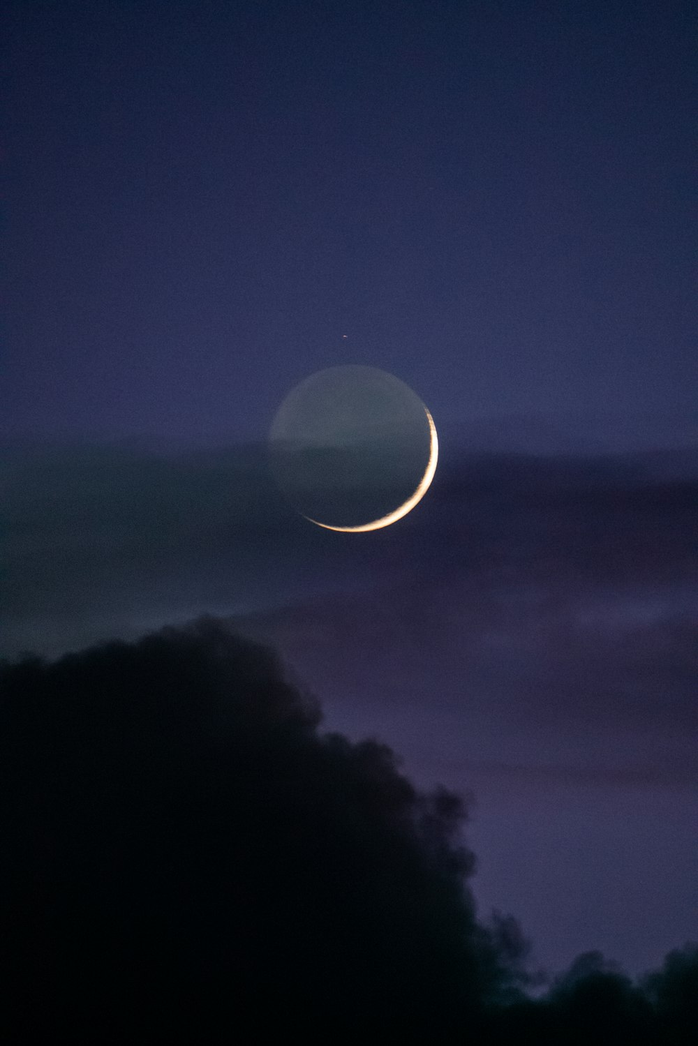 um crescente é visto no céu noturno