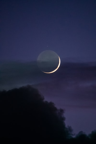 a crescent is seen in the night sky