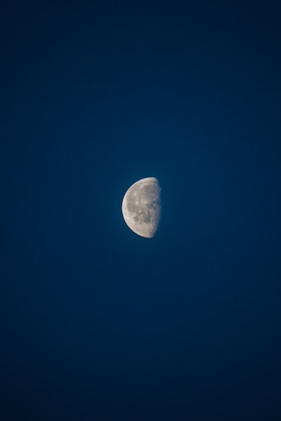 a half moon in a dark blue sky