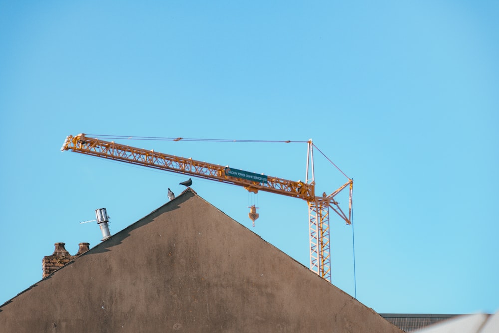 a crane on top of a building with a sky background