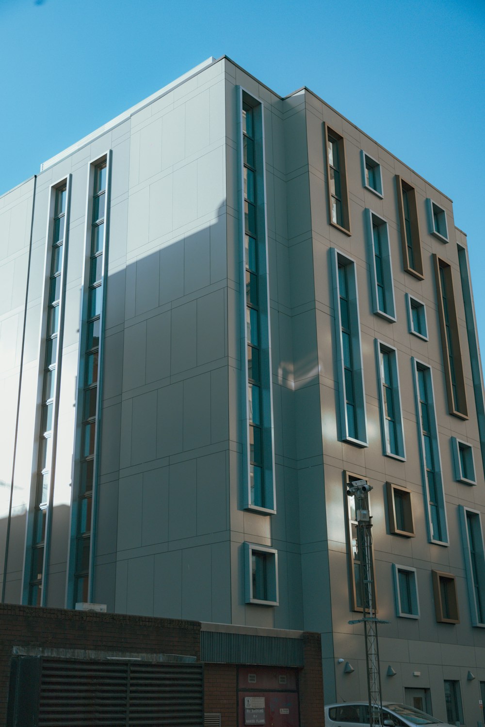 ein hohes Gebäude mit vielen Fenstern neben einer Straße