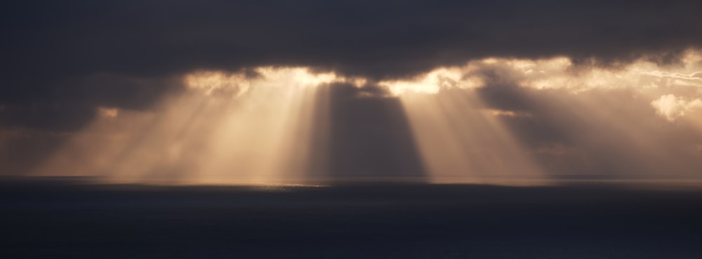 the sun shines through the clouds over the ocean