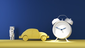 a toy car next to a clock on a table