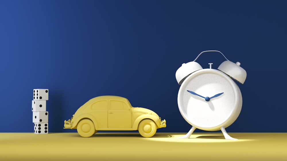a toy car next to a clock on a table