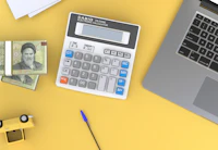 Calculator next to a laptop