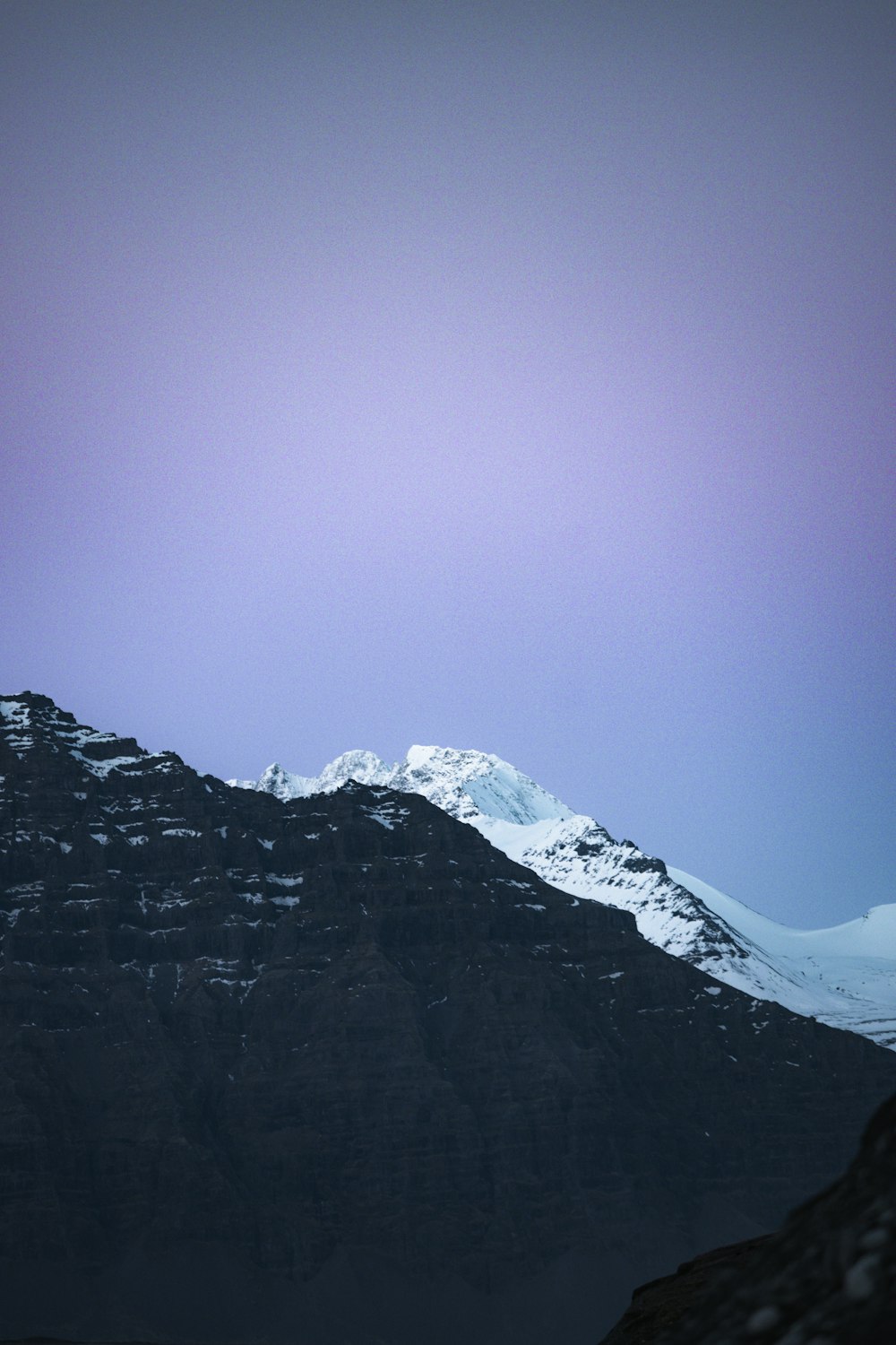 a snow covered mountain with a purple sky in the background