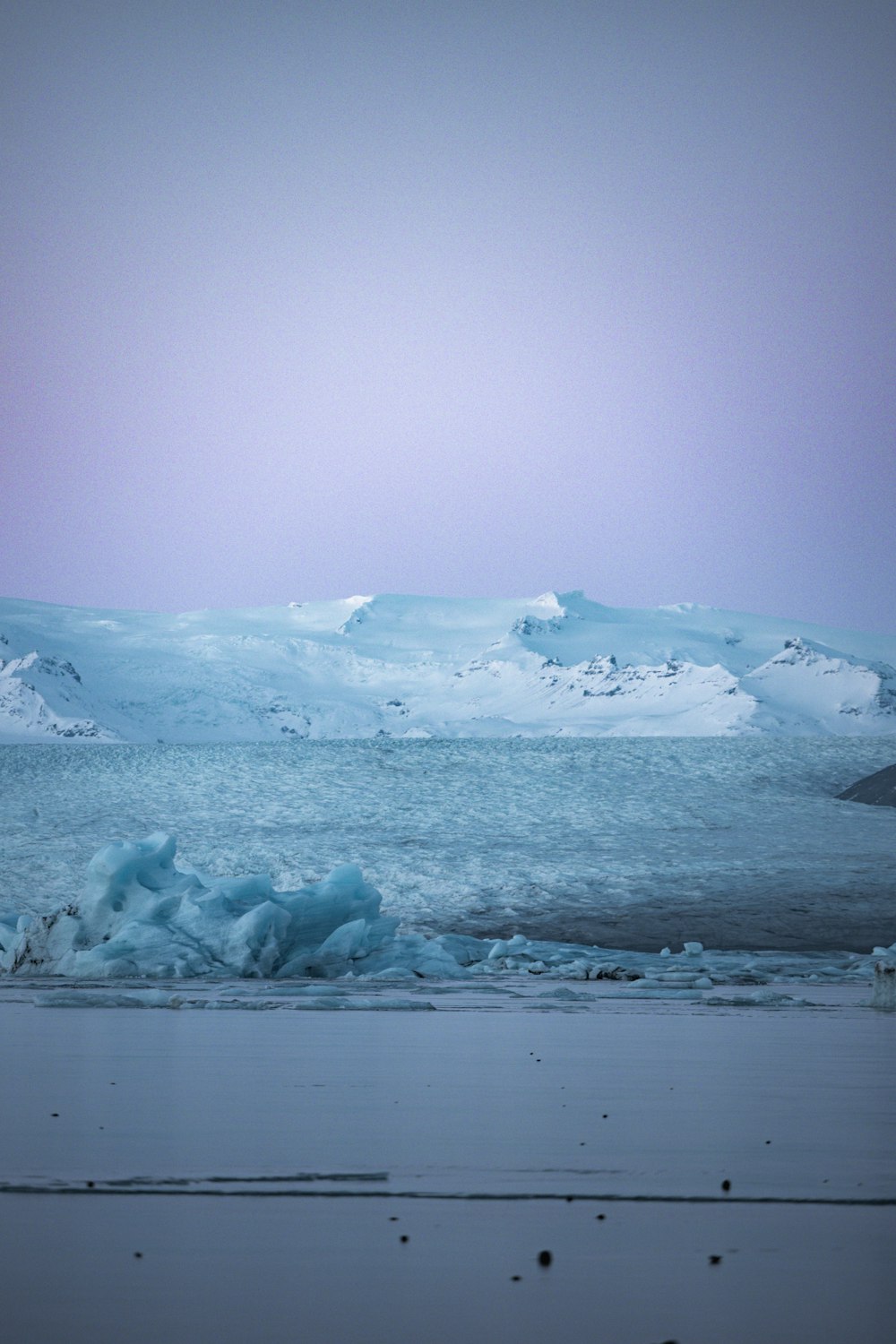 a large body of water surrounded by snow covered mountains