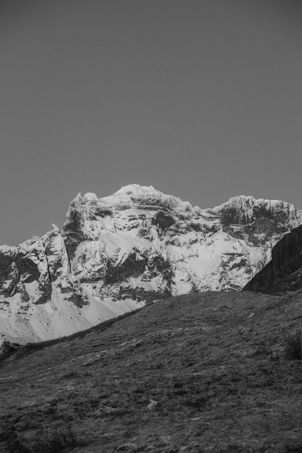 a black and white photo of a snow covered mountain