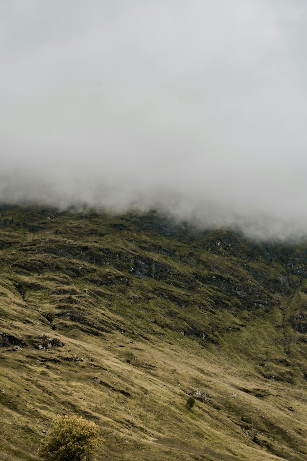 una colina cubierta de hierba y nubes en un día nublado