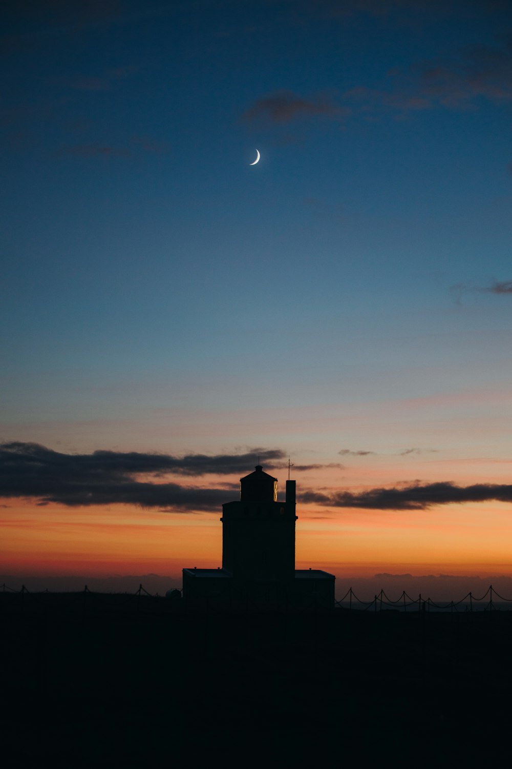 una piccola torre con una mezzaluna nel cielo