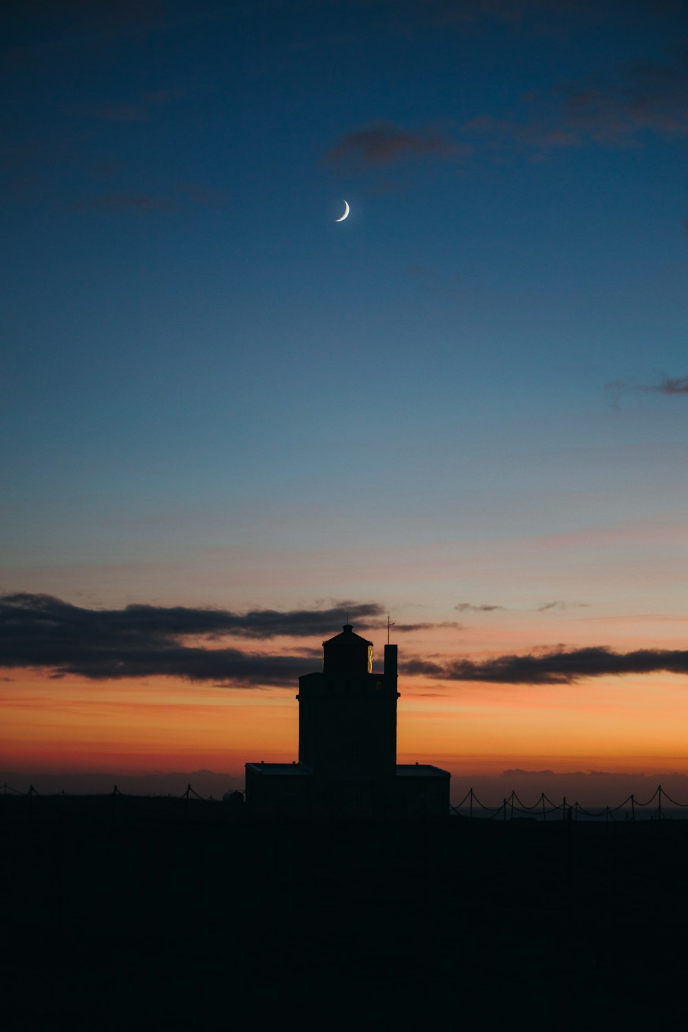 a small tower with a crescent in the sky