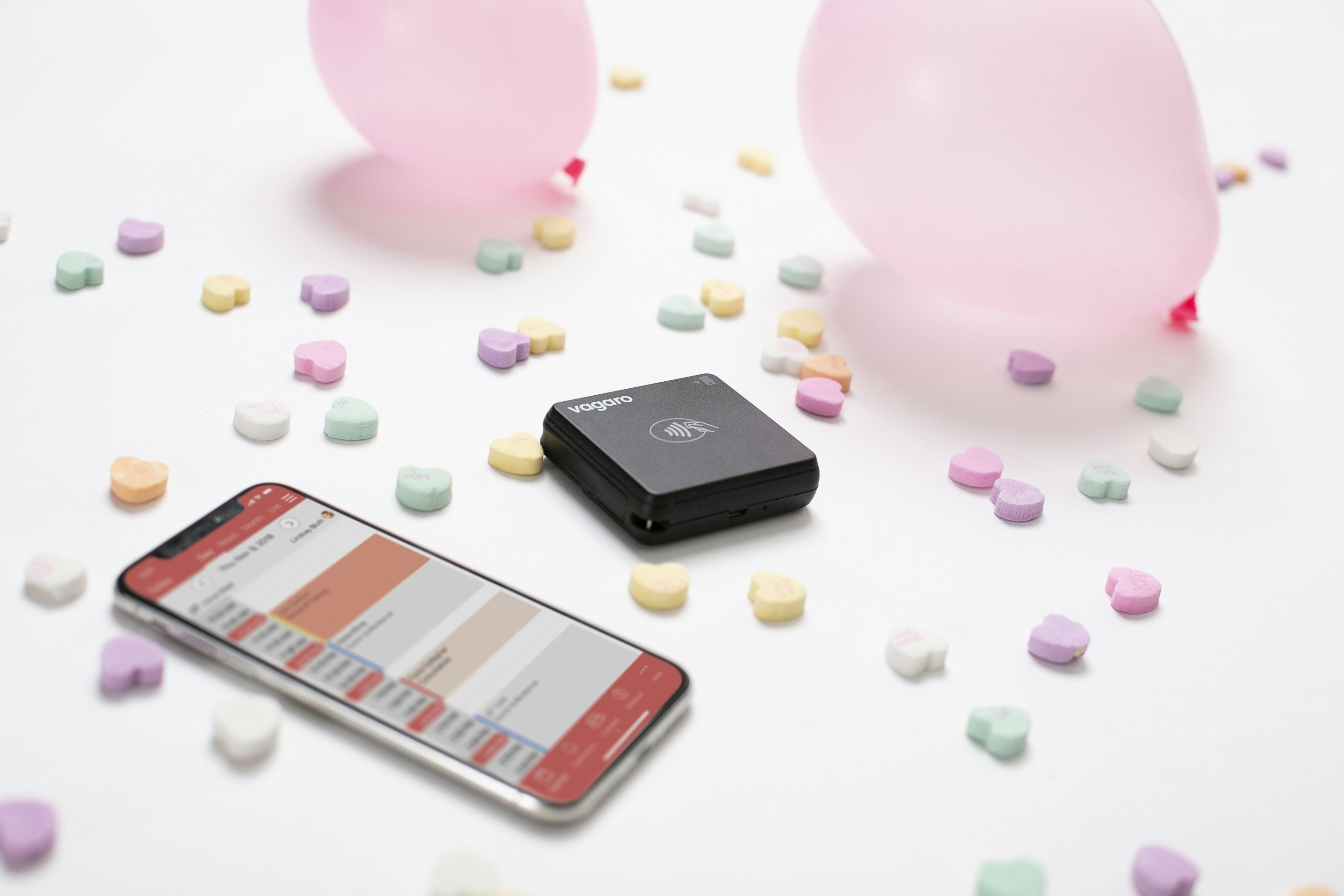 Vagaro contactless card reader and iPhone surrounded by Valentine's decorations