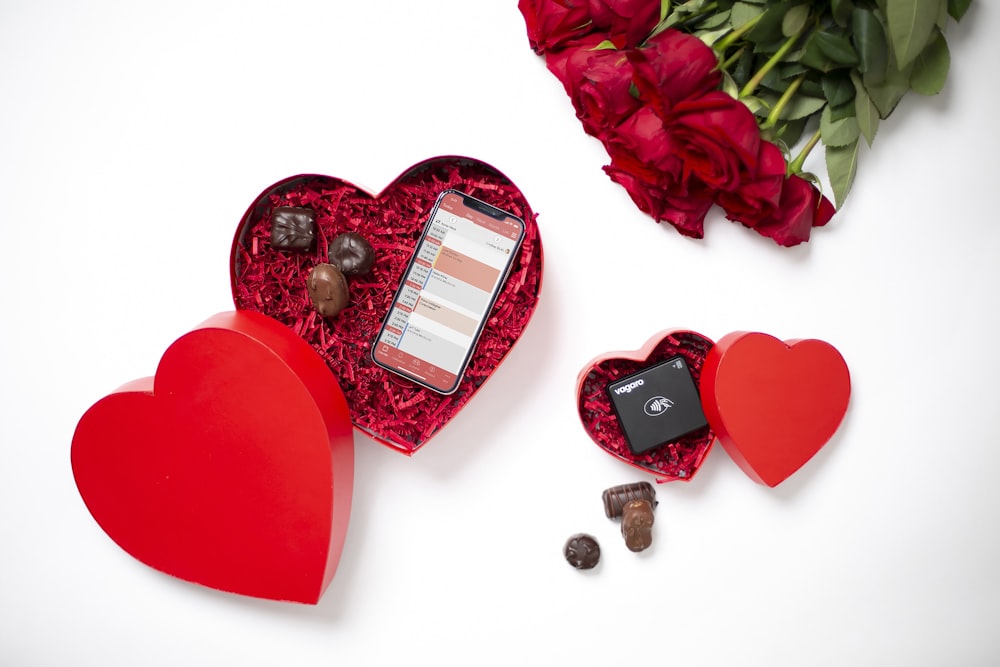 Una caja de San Valentín con un celular y chocolates