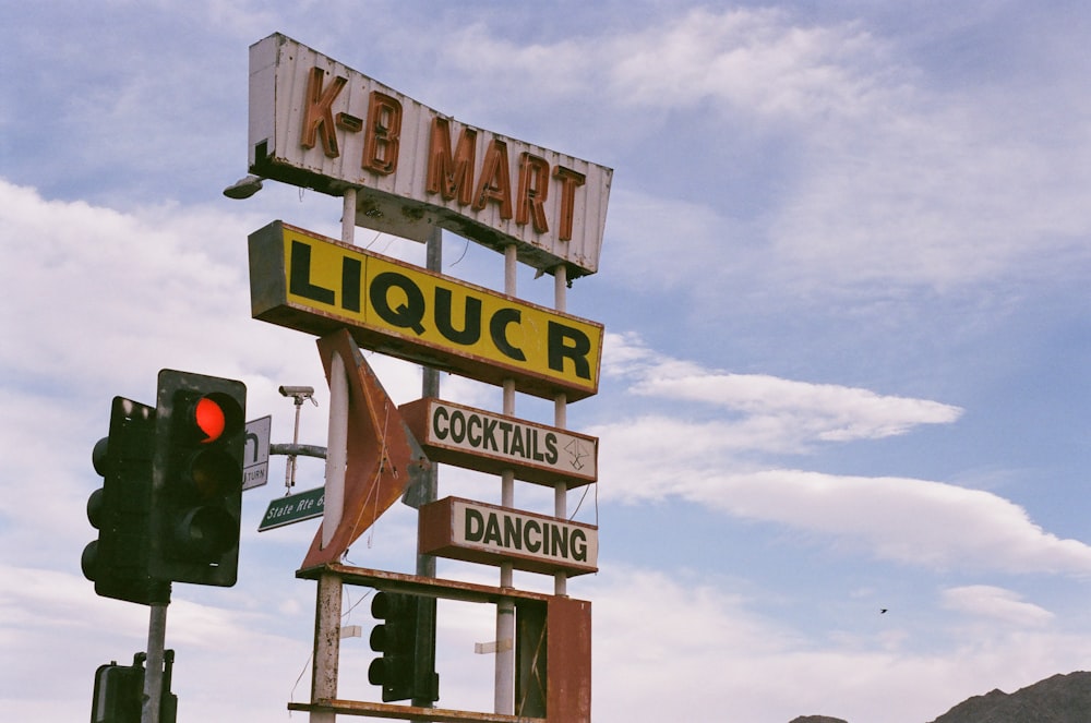 a sign for a liquor store on top of a traffic light