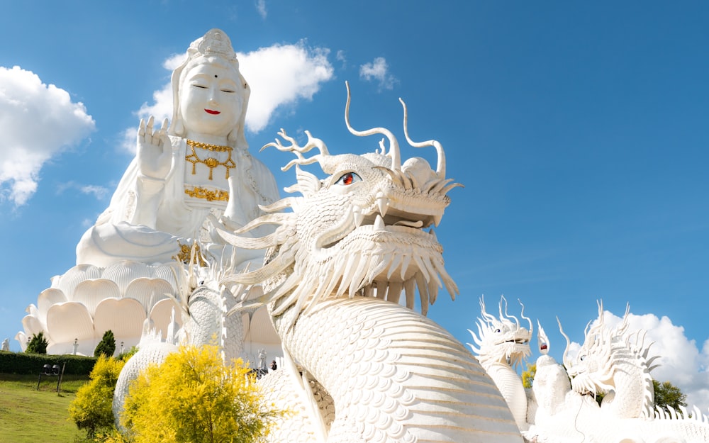 una estatua de un dragón blanco y una estatua blanca de un dragón blanco