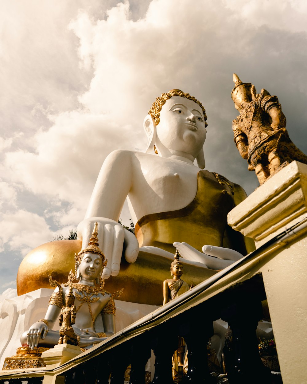 una statua di una persona seduta in cima a una statua d'oro