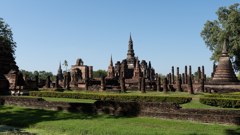 a large group of buildings sitting next to a lush green field