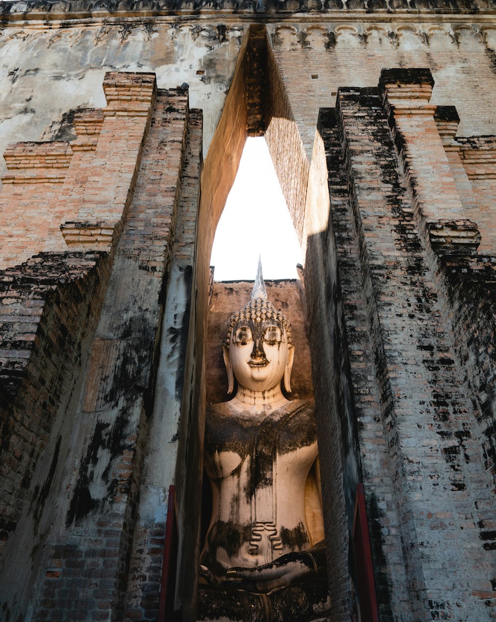 une grande statue de Bouddha assise au milieu d’un bâtiment