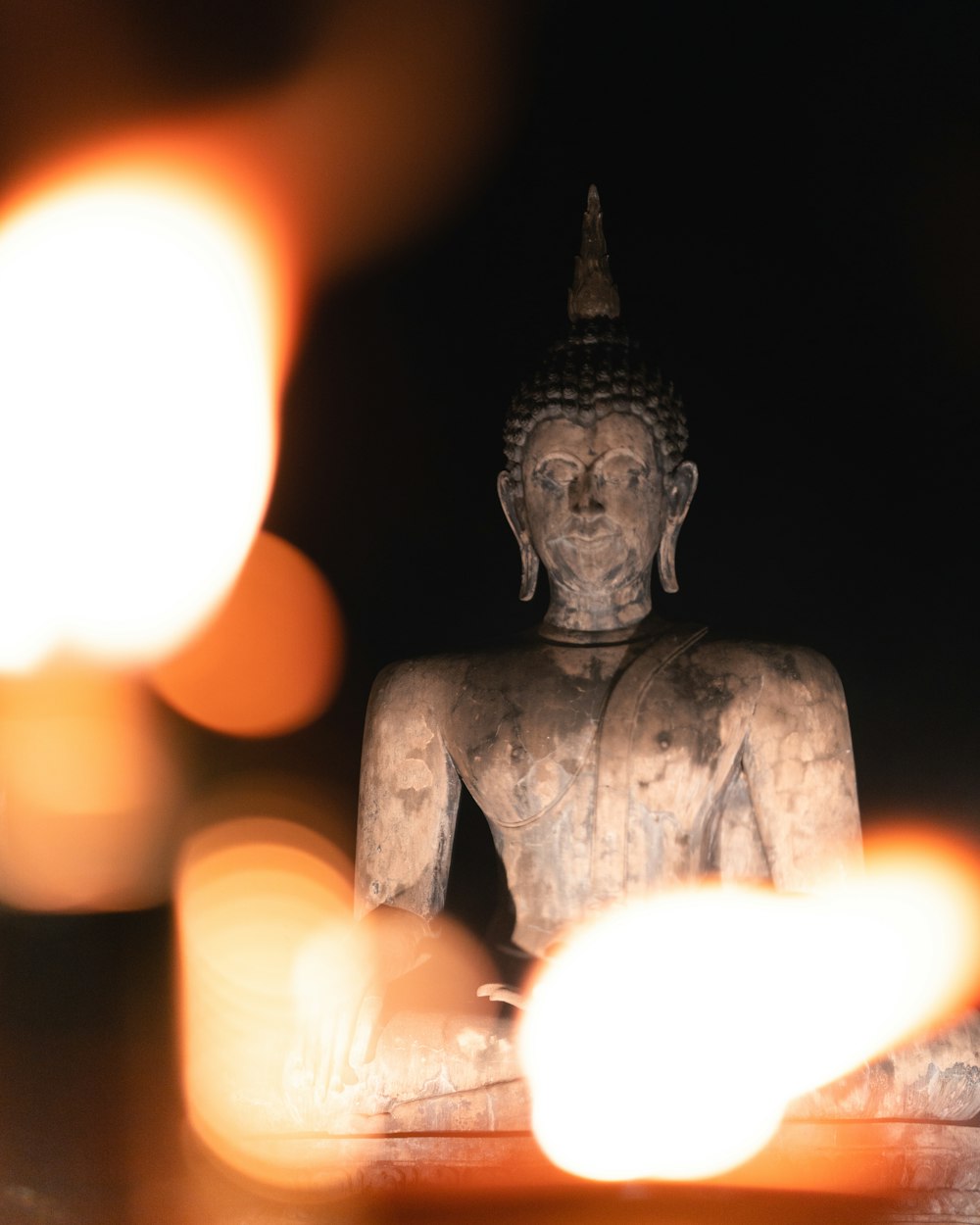 a buddha statue sitting in the middle of a dark room