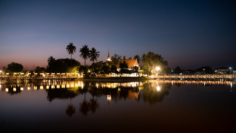 a body of water at night with a clock tower in the background