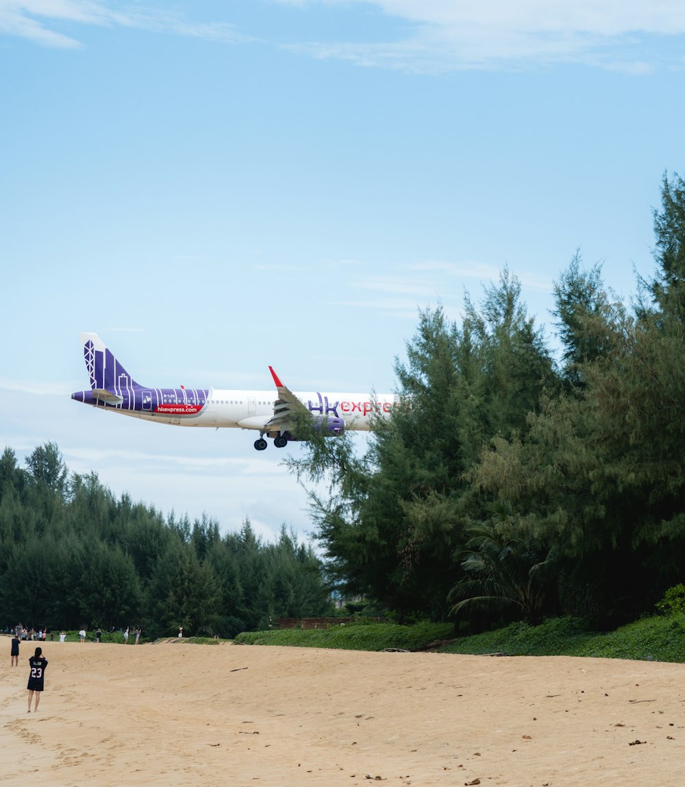a plane is flying low over a beach