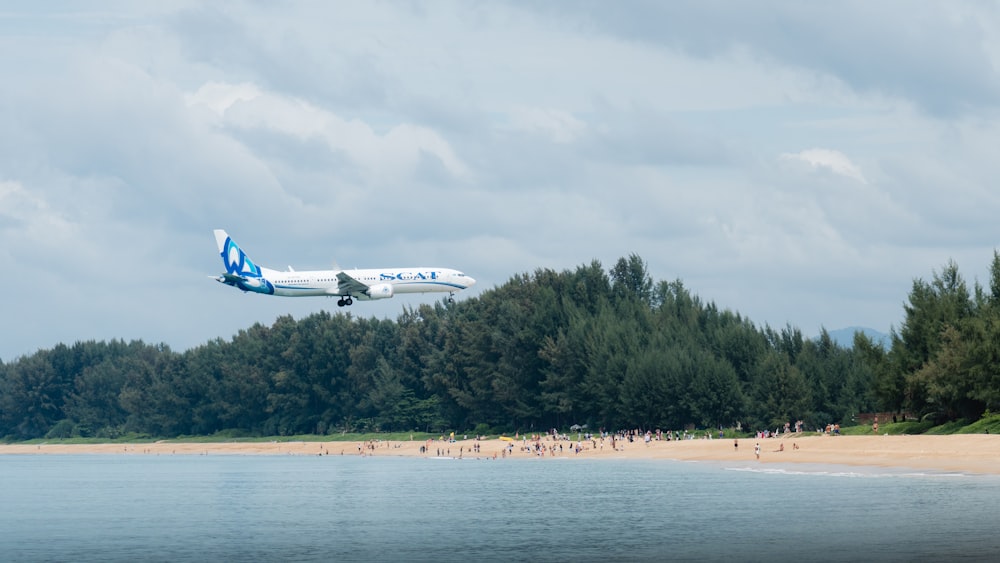 a plane is flying low over a beach