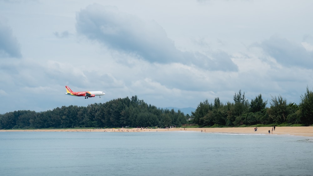 a plane is flying over a beach and trees